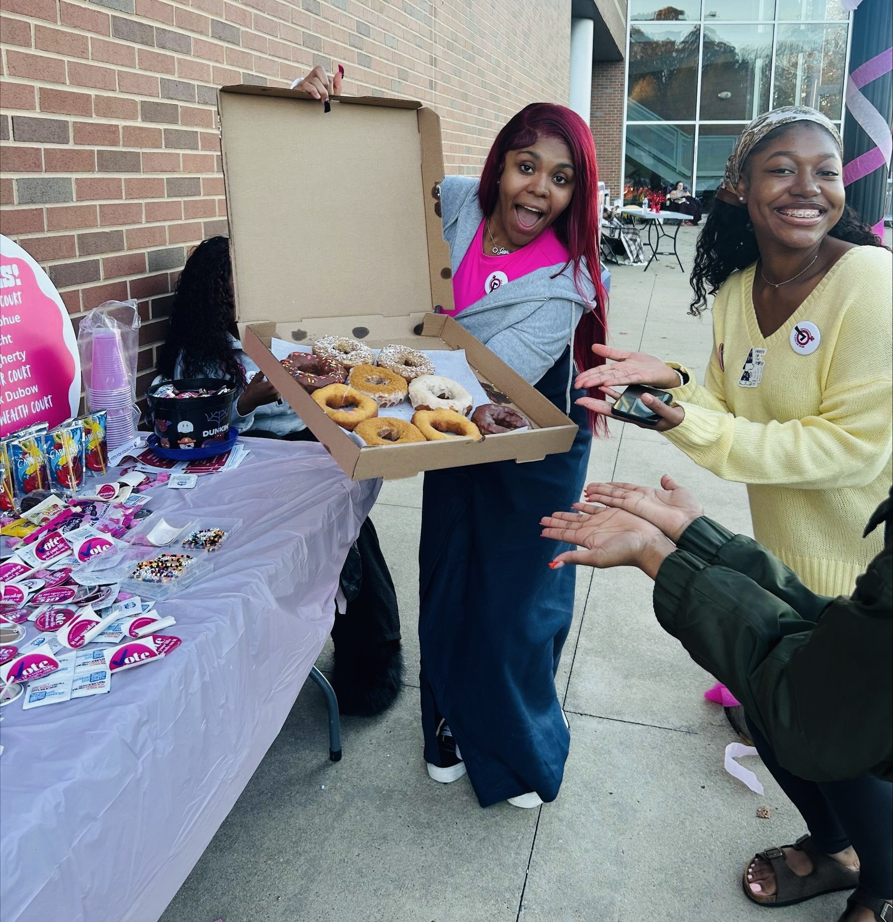 A group showing off donuts at a tabling event