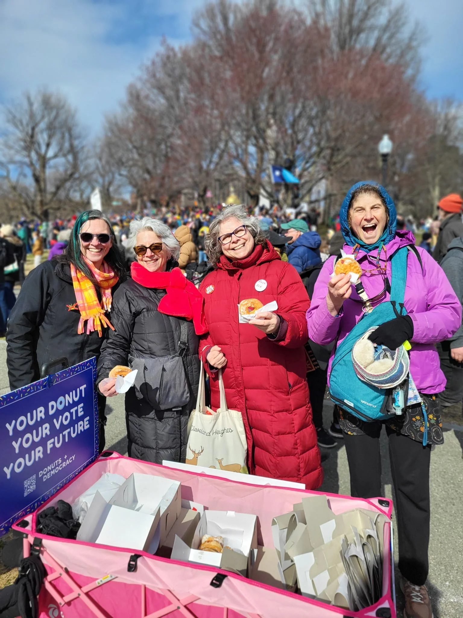 Four people with a donut wagon and donuts