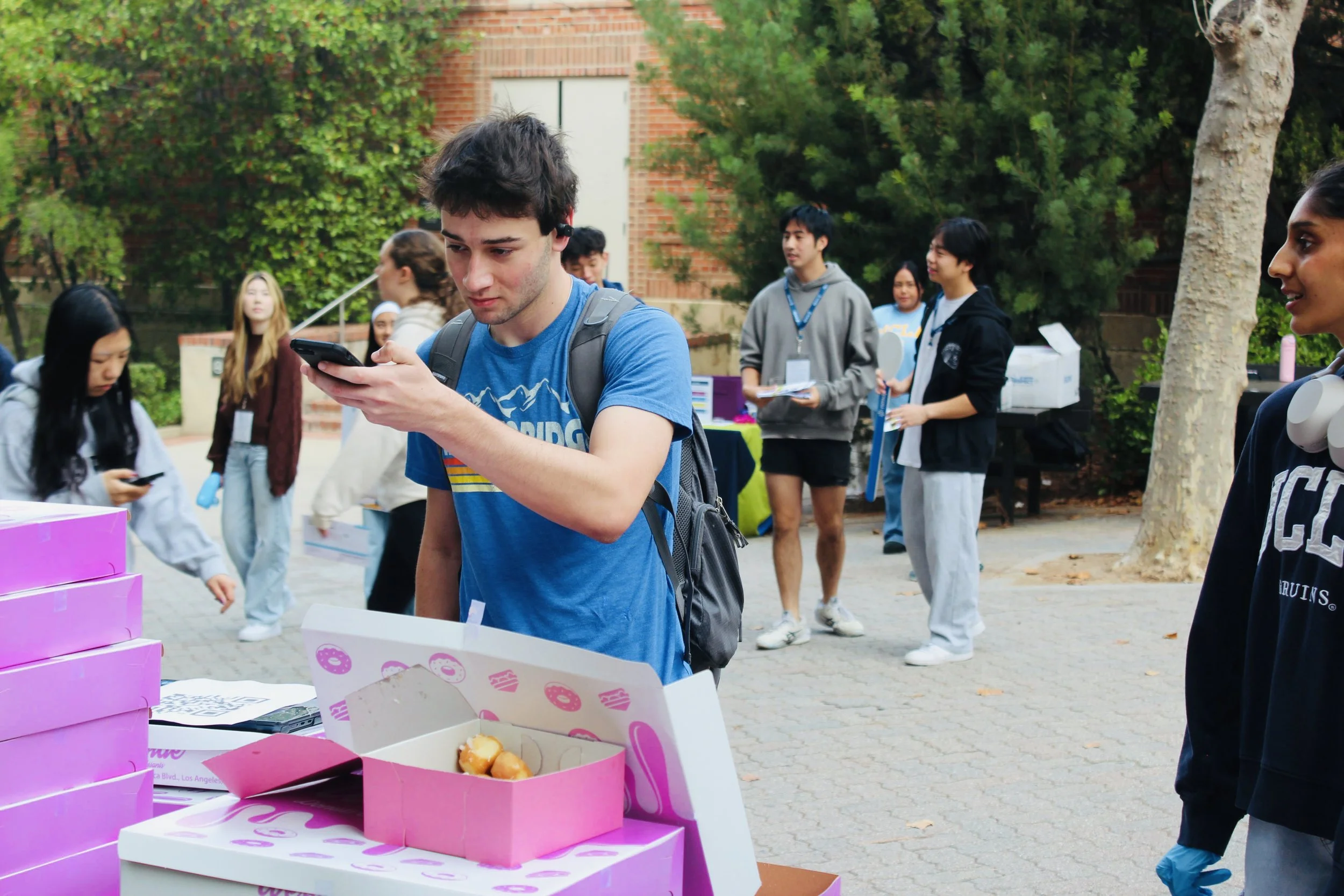 Person scanning a qr code surrounded by donut boxes