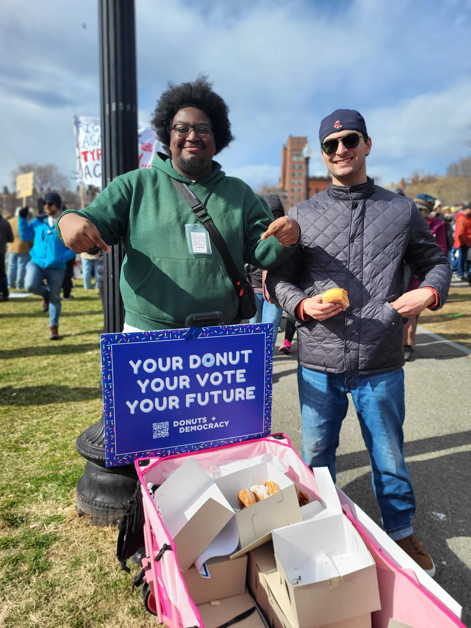 Two people with a donut wagon and a sign that says "Your donut, your vote, your future"