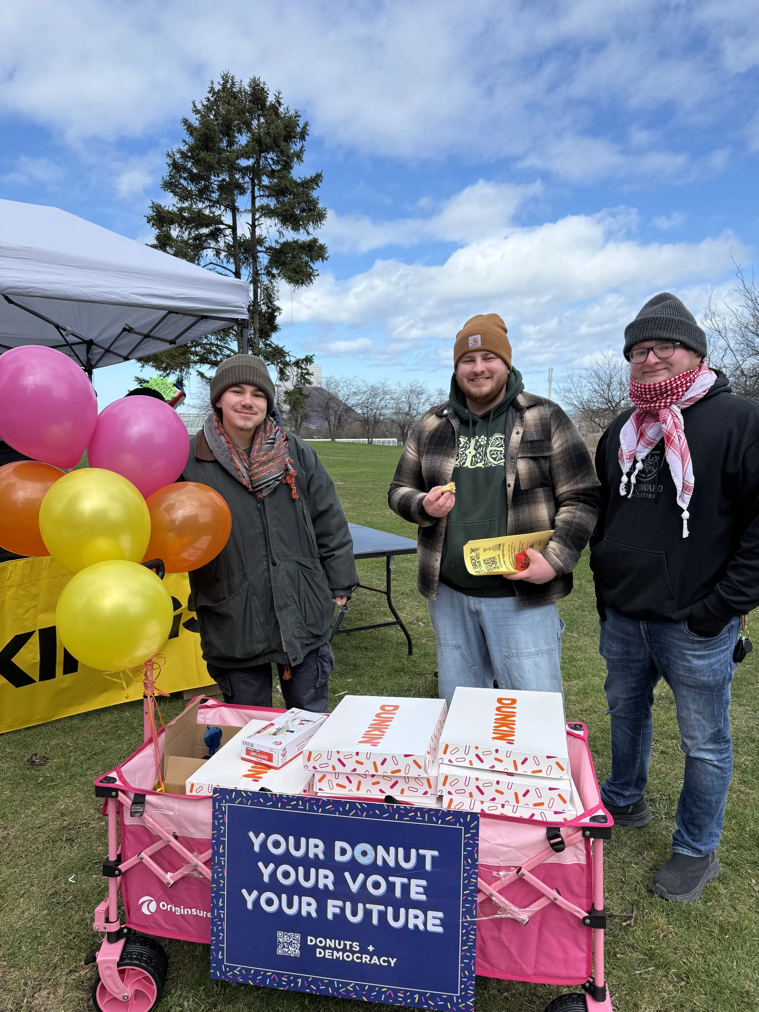 Three people with a full donut wagon