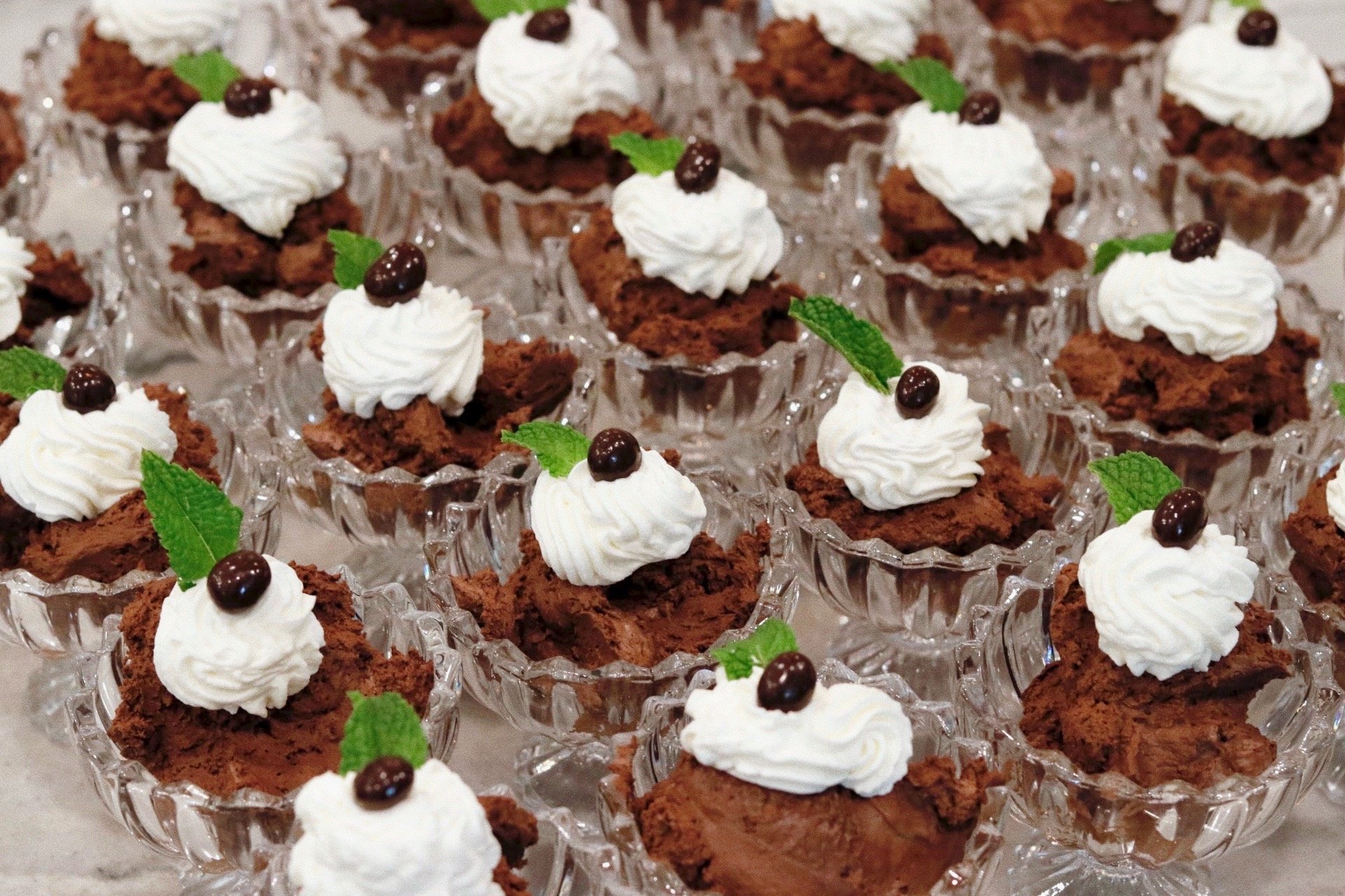 Espresso mousse topped with homemade whipped cream and a mint leaf, prepared by Silver Platter Catering