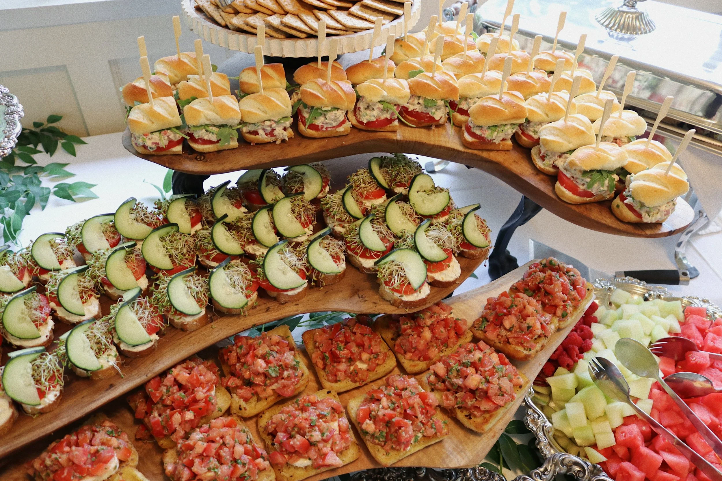 Assortment of bruschetta, cucumber sandwiches, and Buffalo Chicken Salad sliders prepared by Silver Platter Catering