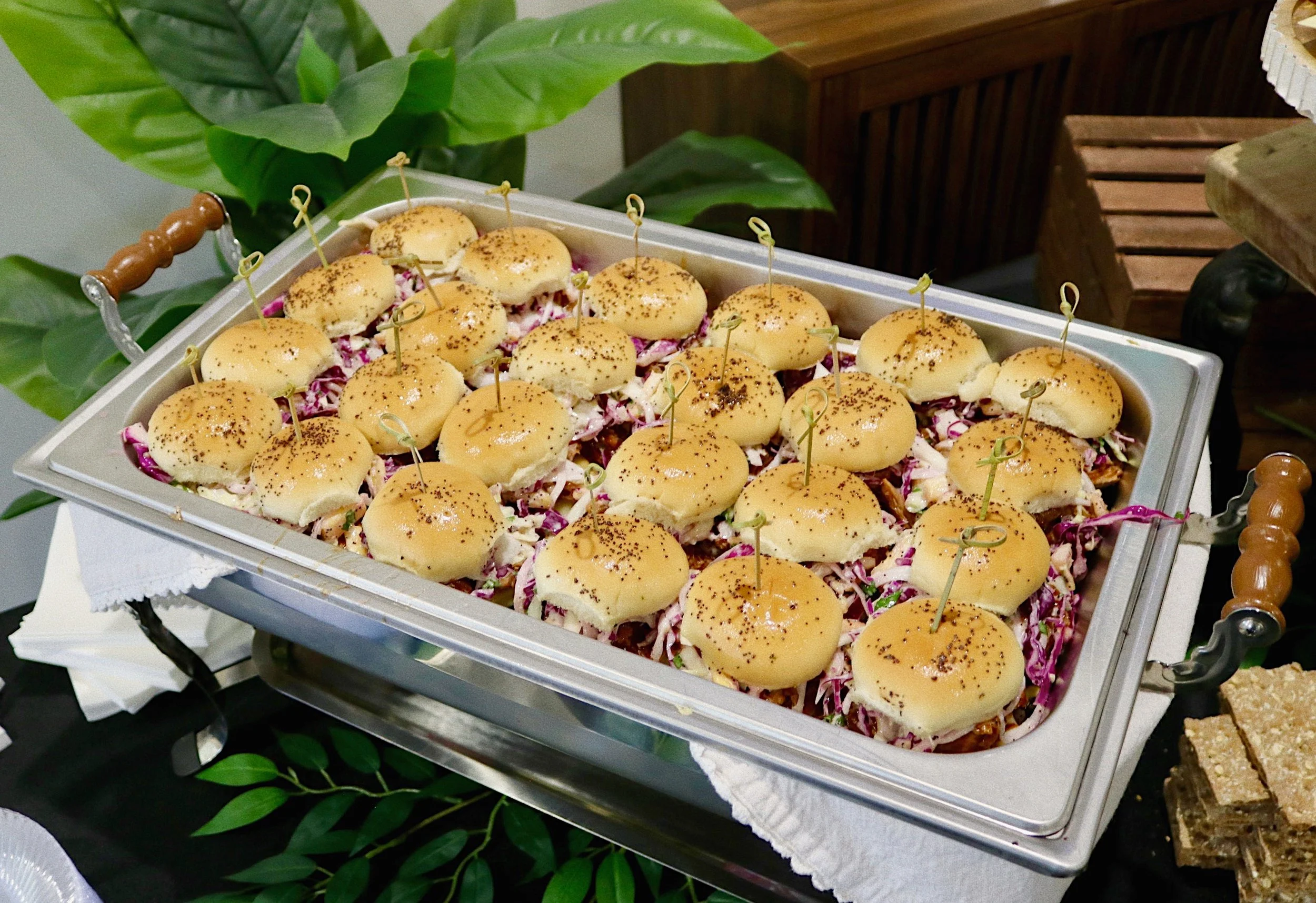 Pulled pork sliders with creamy pineapple, sweet onion, and poppy seed coleslaw, prepared by Silver Platter Catering