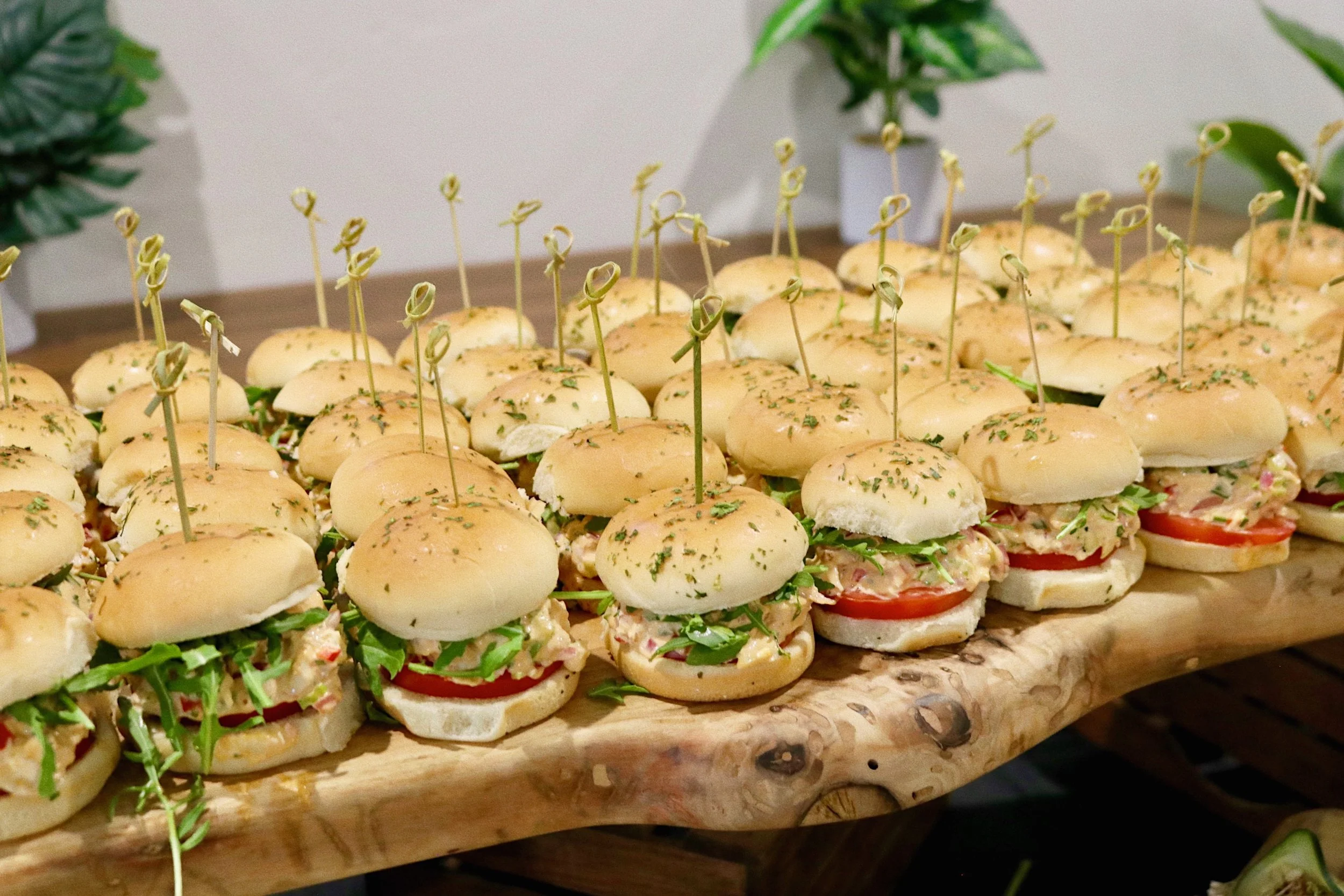 Smoked chicken salad sandwiches presented on a wooden serving board, prepared by Silver Platter Catering