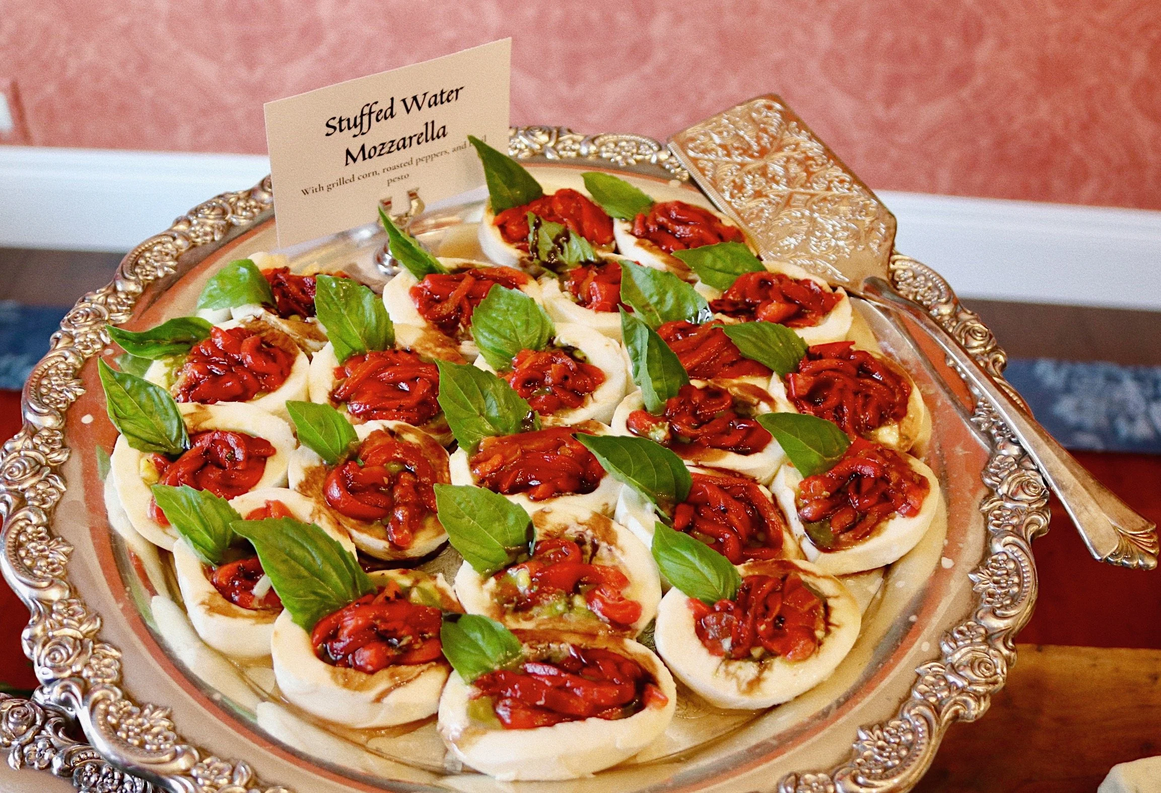 Stuffed water mozzarella with grilled corn, roasted peppers, and basil pesto, prepared by Silver Platter Catering