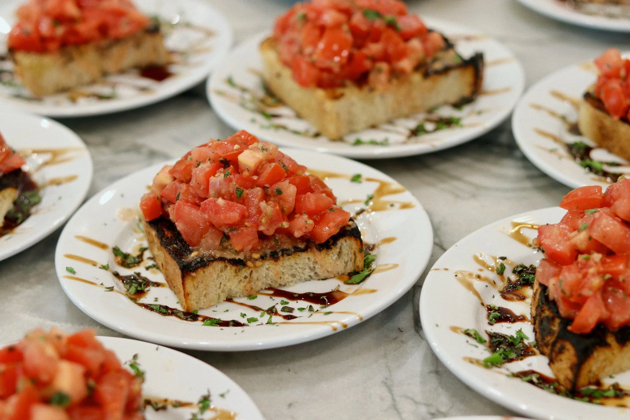Plated bruschetta appetizer topped with balsamic glaze, prepared by Silver Platter Catering