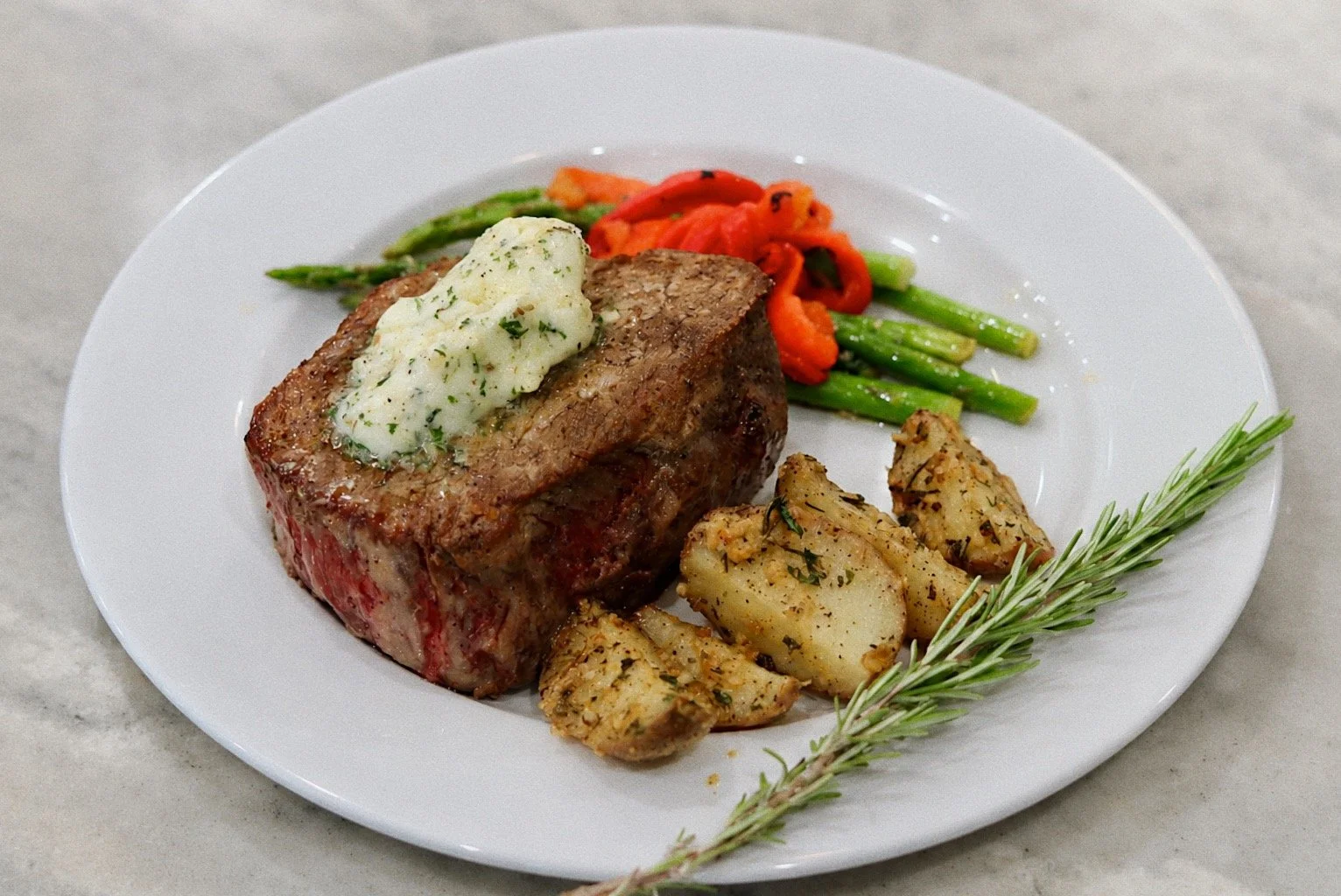 Plated steak dinner with roasted potatoes and asparagus prepared by Silver Platter Catering