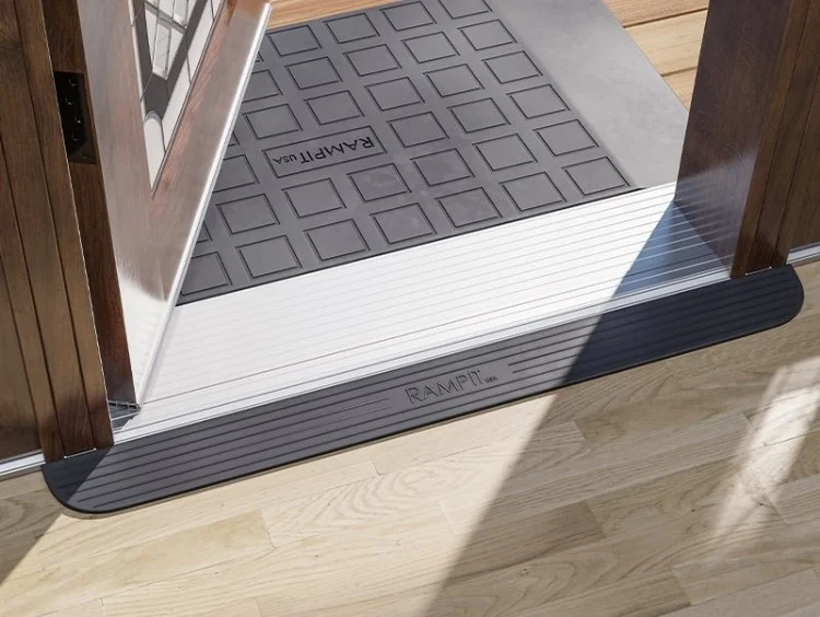 Entrance floor with a portable ramp and rubber doormat.