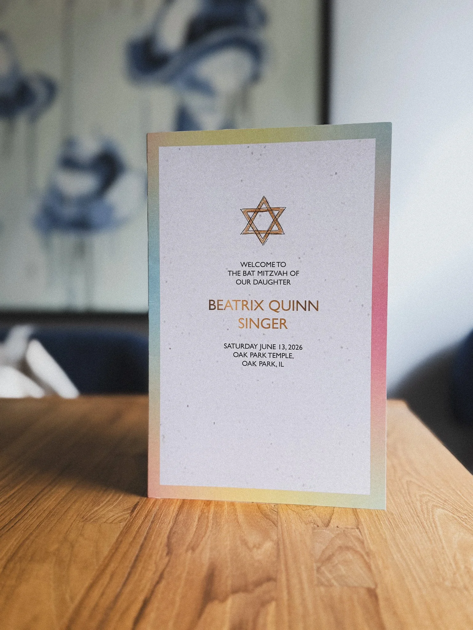 A colorful invitation or program card for a bat mitzvah celebration with the name Beatrix Quinn, a singer, and the date June 13, 2026, at Oak Park Temple in Oak Park, Illinois.