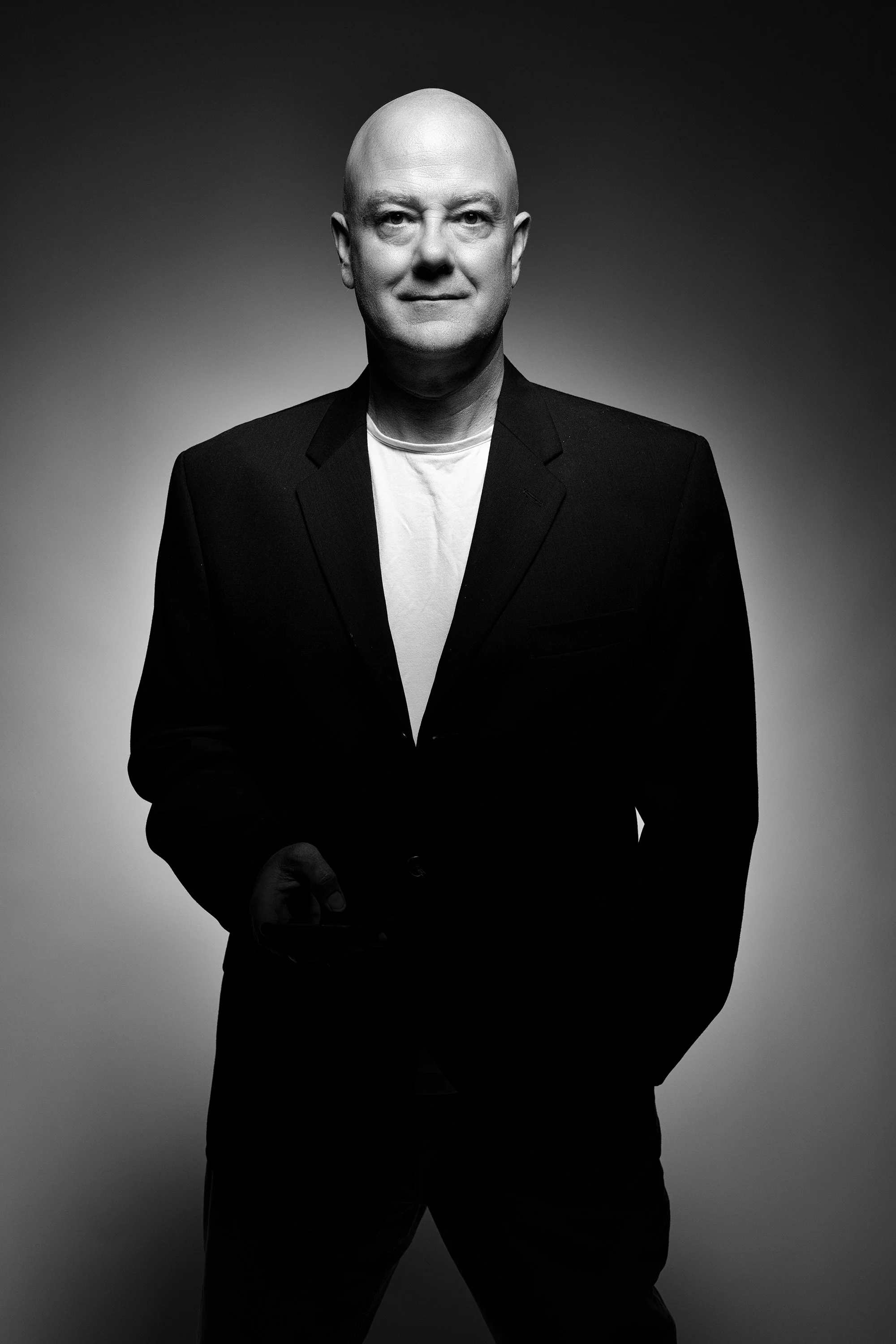 Black and white studio portrait of a man in a dark suit jacket, Kelly Corder photography.
