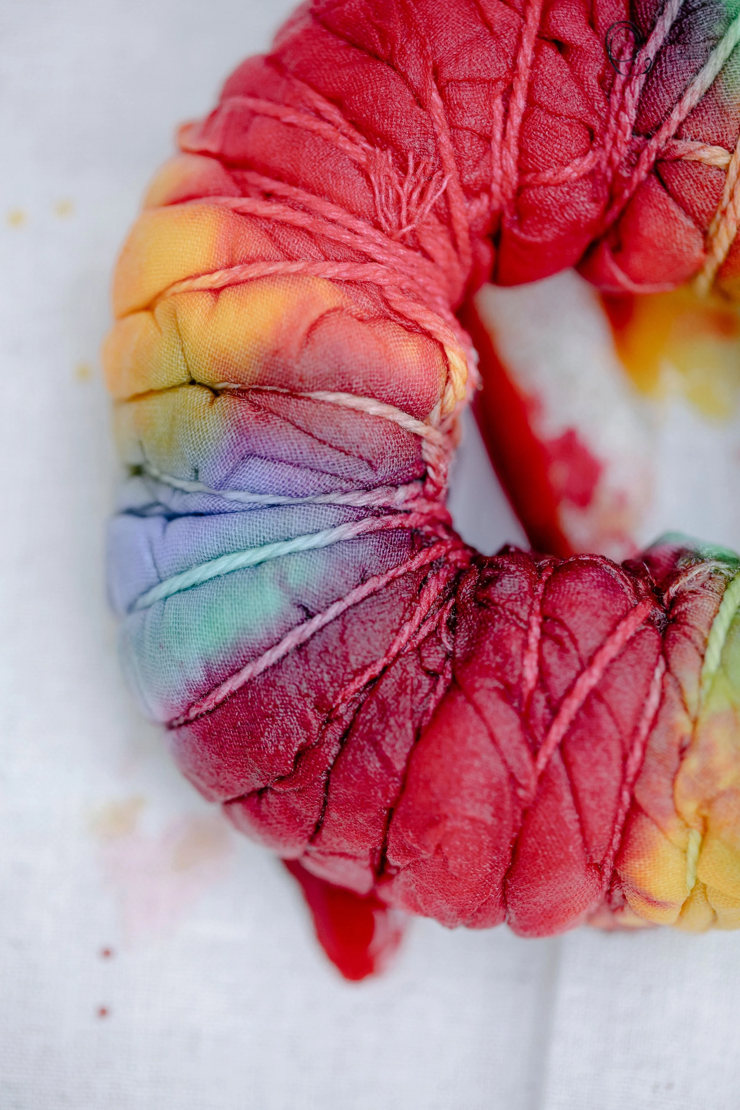 Close-up of a vibrant tie-dye textile with intricate colors and patterns.