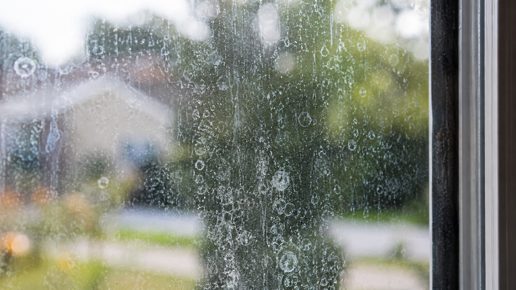 Hard water spots and mineral buildup on residential window glass