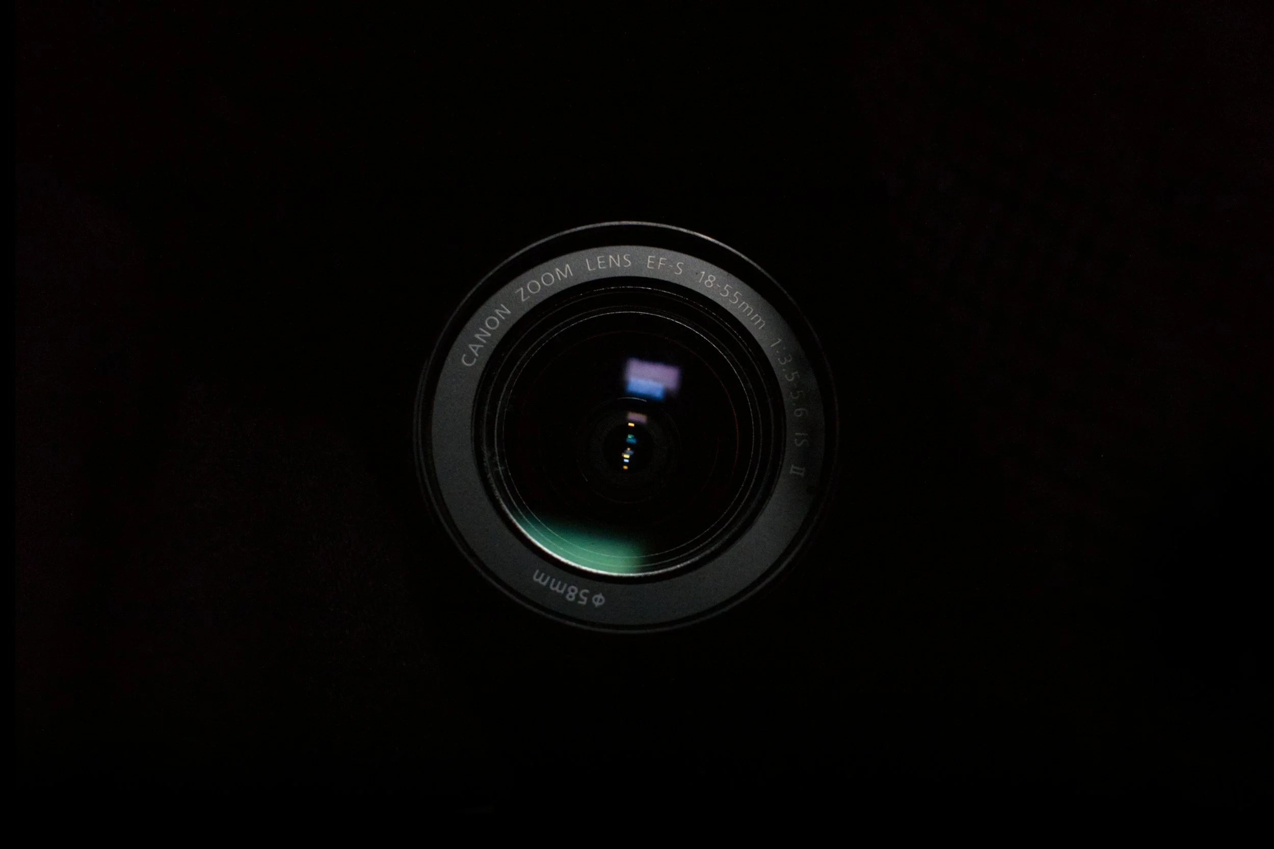 Close-up of a camera lens against a black background.