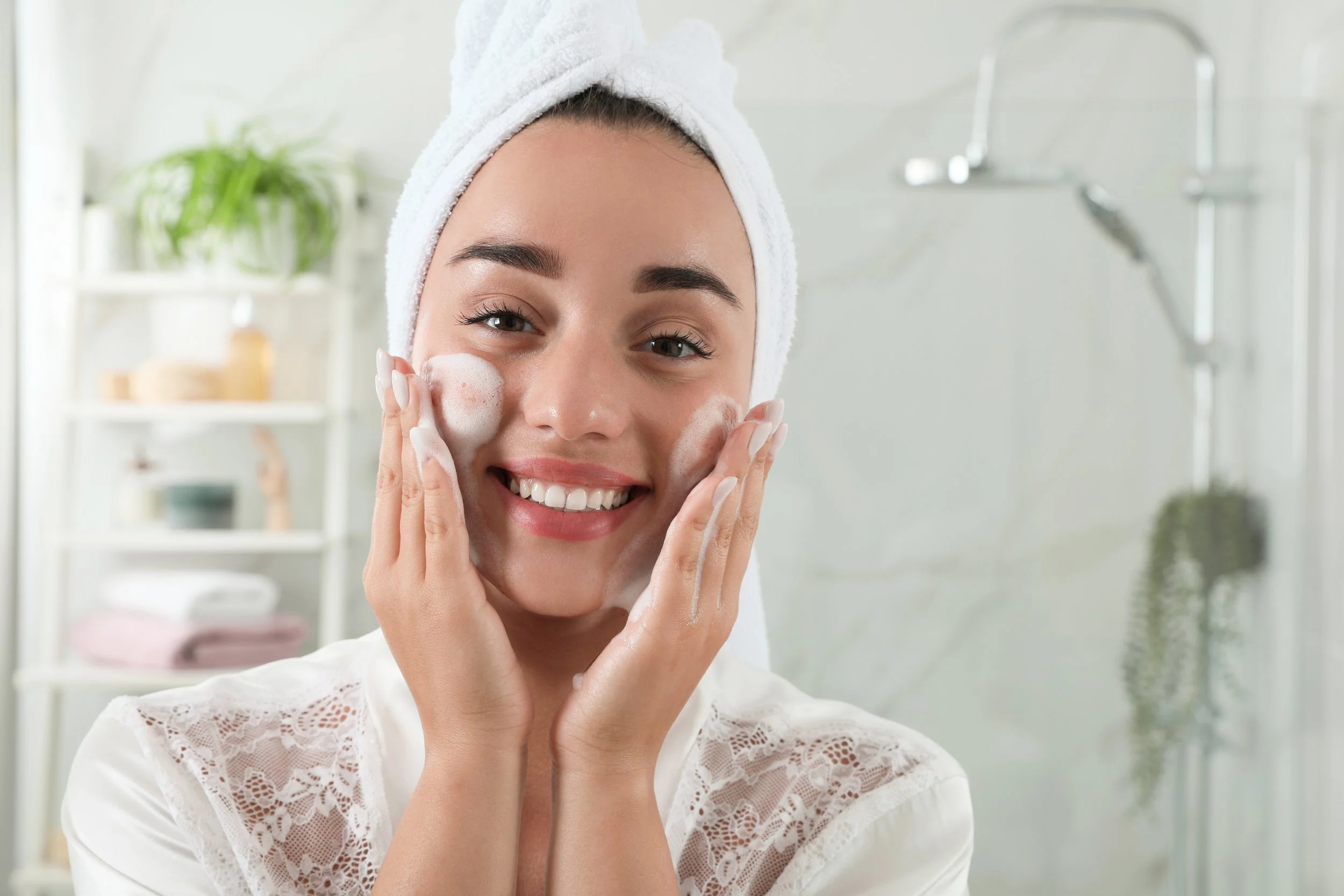 beautiful young woman applying cleansing foam onto face bathroom skin care cosmetic