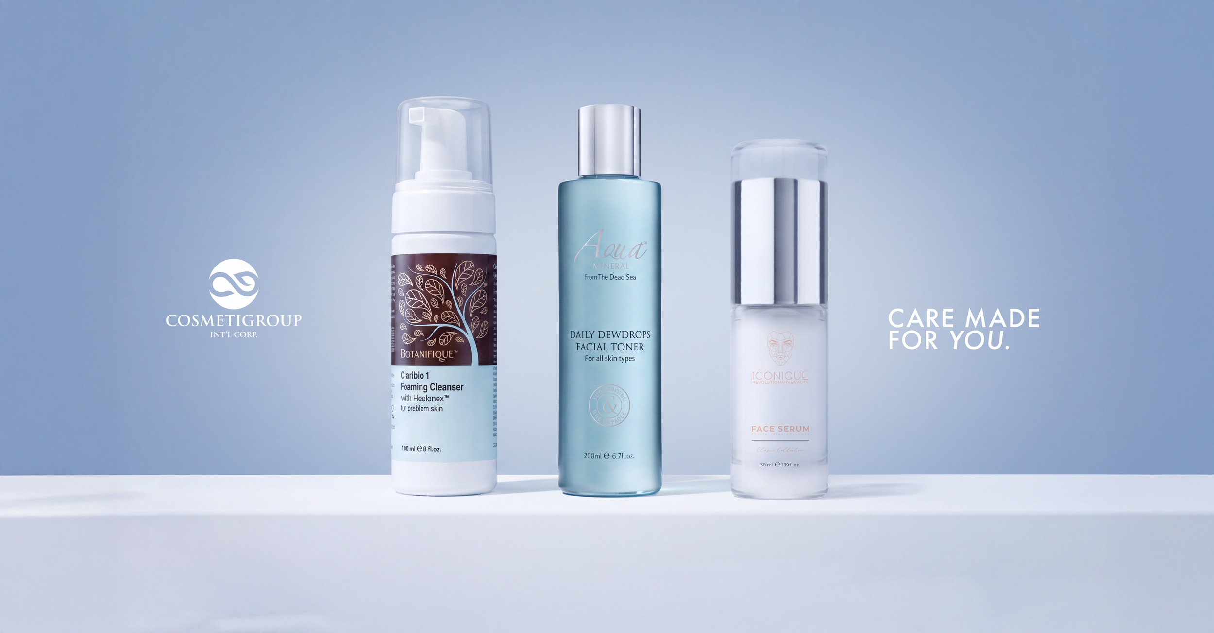 Three skincare products on a white surface with a light blue background. The left product is a bottle of foaming cleanser with a pump, the middle is a blue facial toner, and the right is a clear bottle of face serum. Text on the image includes 'COSMETIGROUP', 'CARE MADE FOR YOU.'