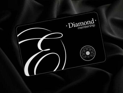 Black membership card with white decorative design, text reading "Diamond membership," and a circular emblem, resting on black satin fabric.