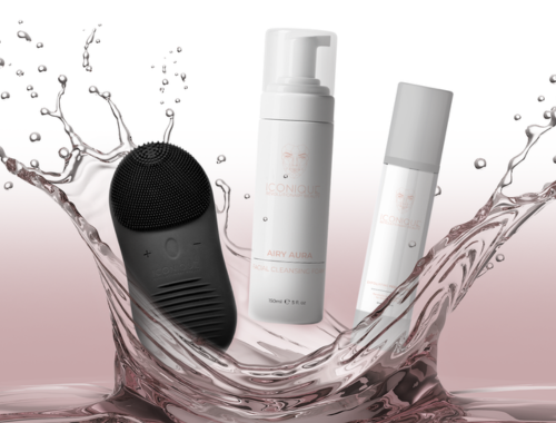 Skincare products and a black facial cleansing device splashing into water