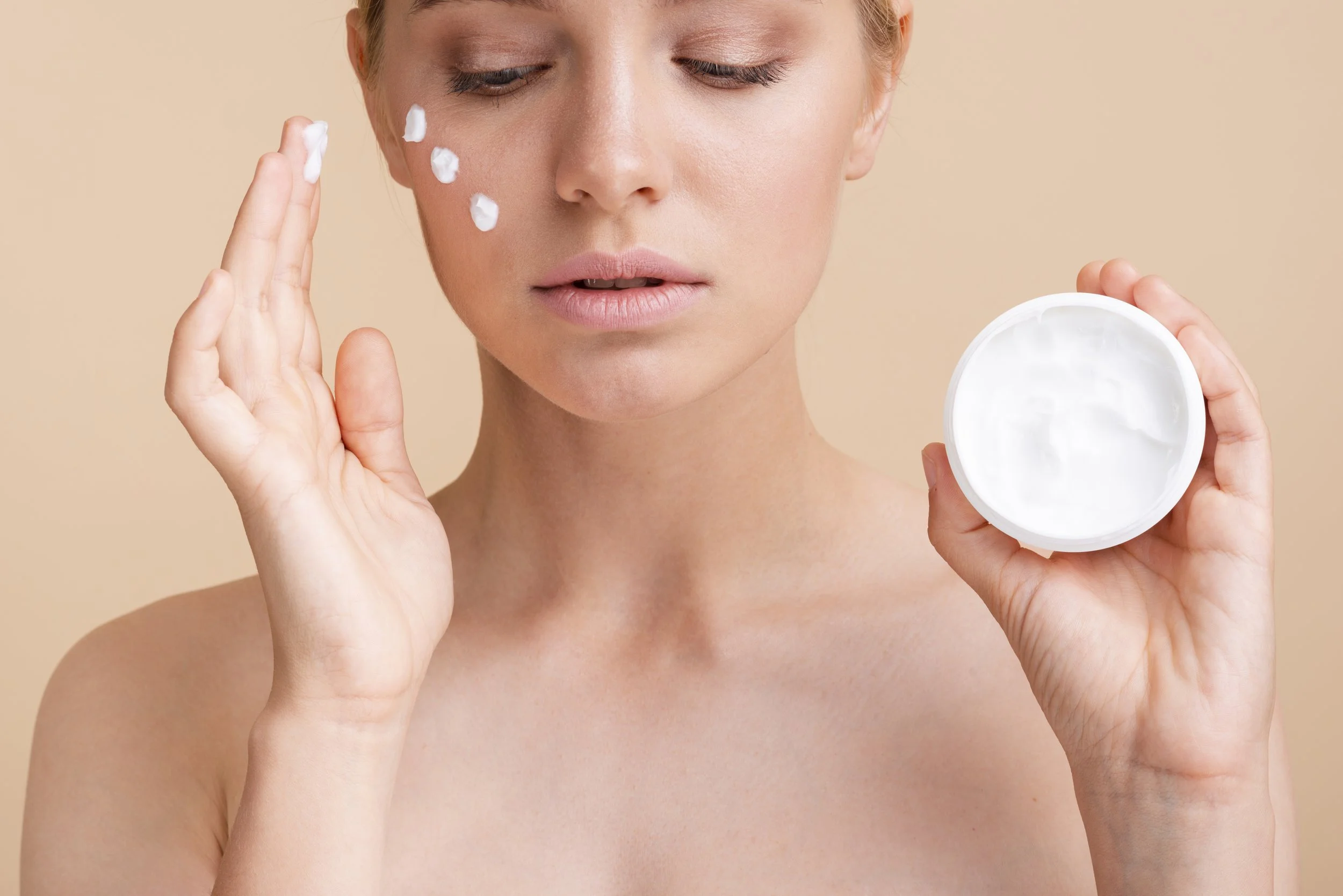 close up beautiful woman with face cream jar.jpg