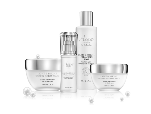 Set of four skincare products: detox mask, facial serum, cleansing soap, and moisturizing cream, with water droplets around.