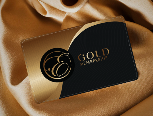 Gold and black membership card with a decorative logo, placed on a satin fabric background.