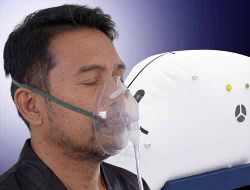 A man wearing a protective oxygen mask connected to a medical device.