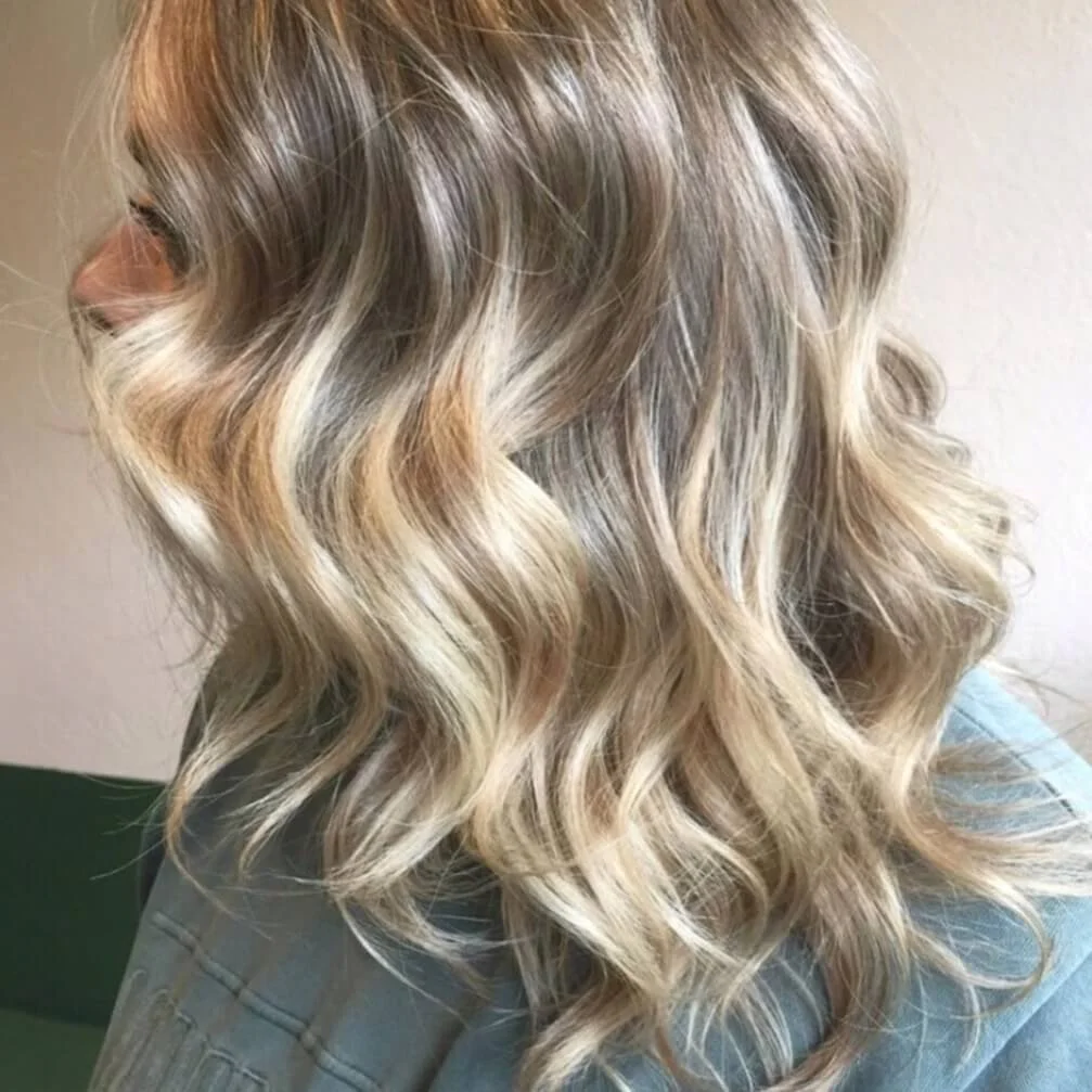 Close-up of blonde, wavy hair with highlights.