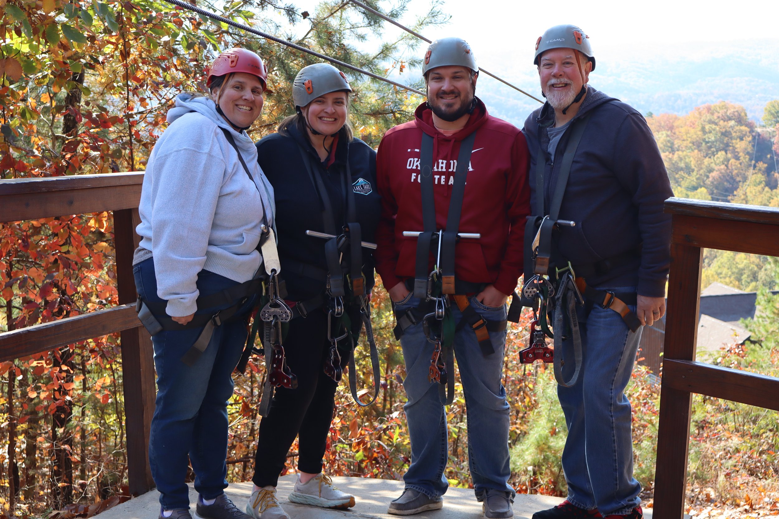 Four family members wearing helmets and harnesses before a ziplining activity in Tennessee.