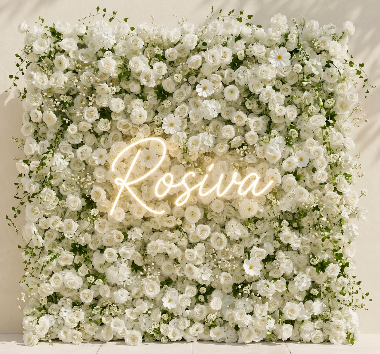 A wall of white roses and flowers, surrounded by greenery.