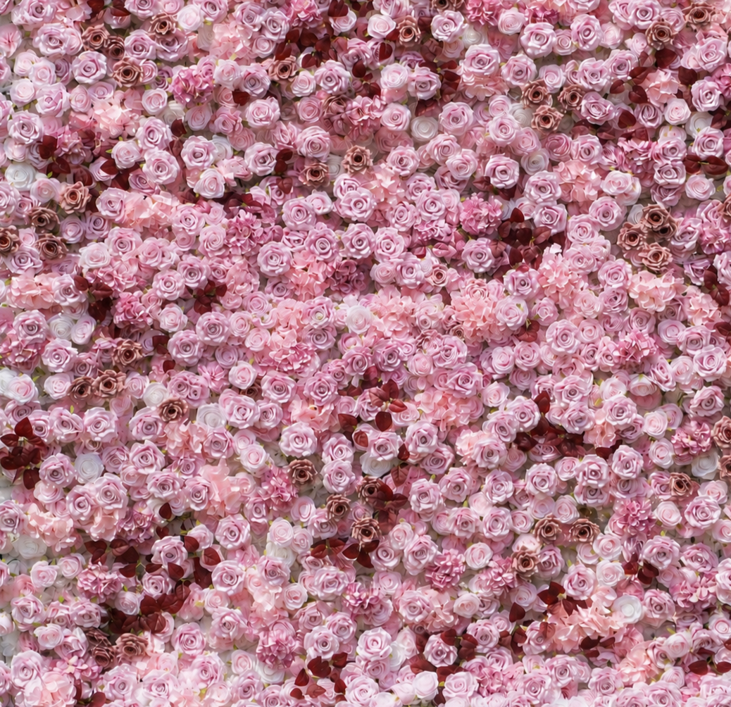 A large display of pink roses with some scattered darker red flowers interspersed throughout.