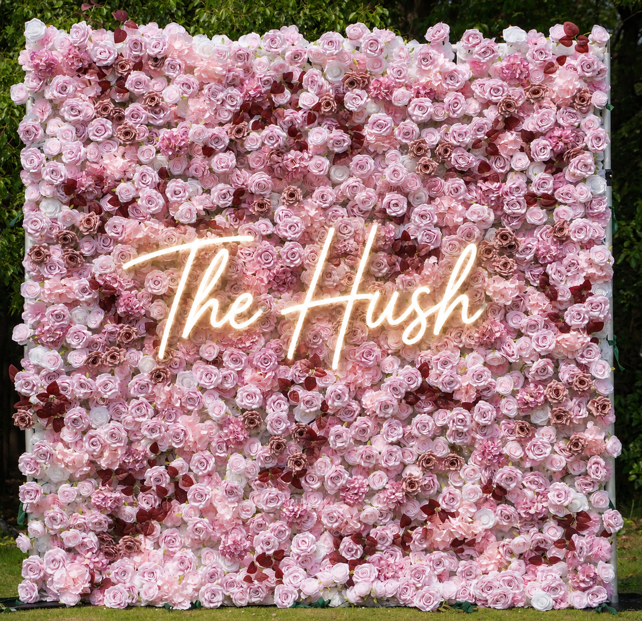 A large floral backdrop made of pink and burgundy roses.