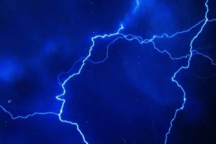 Bright blue lightning bolts against a dark night sky.