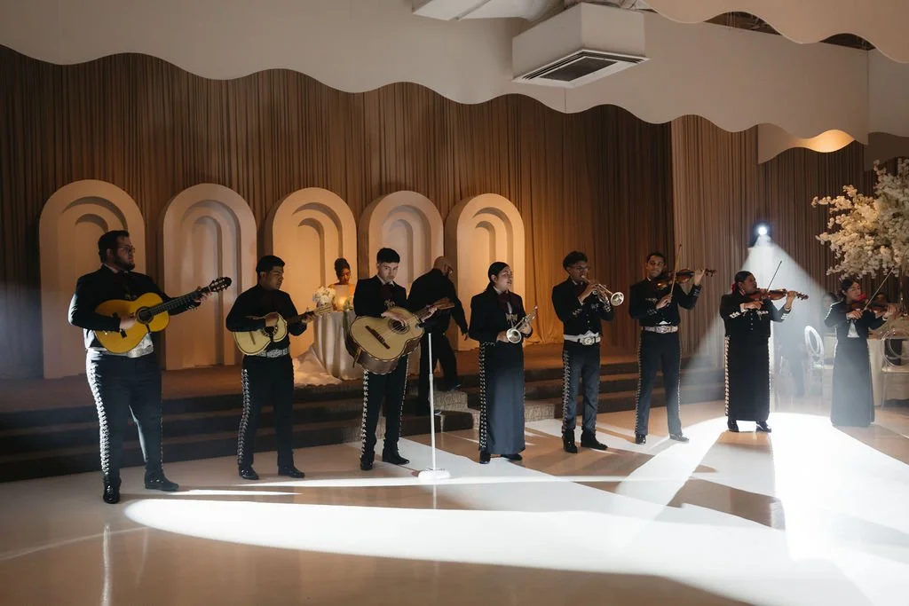 Live mariachi musicians performing beneath dramatic lighting at a Las Vegas wedding reception.