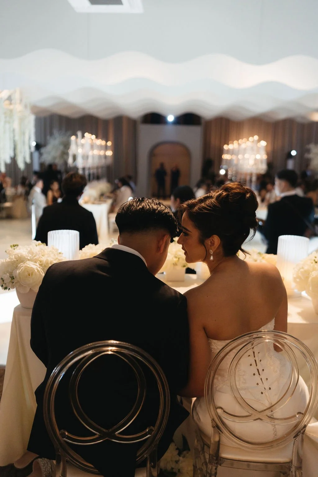 Documentary-style black-and-white photograph of the bride’s father watching her dance at the reception.
