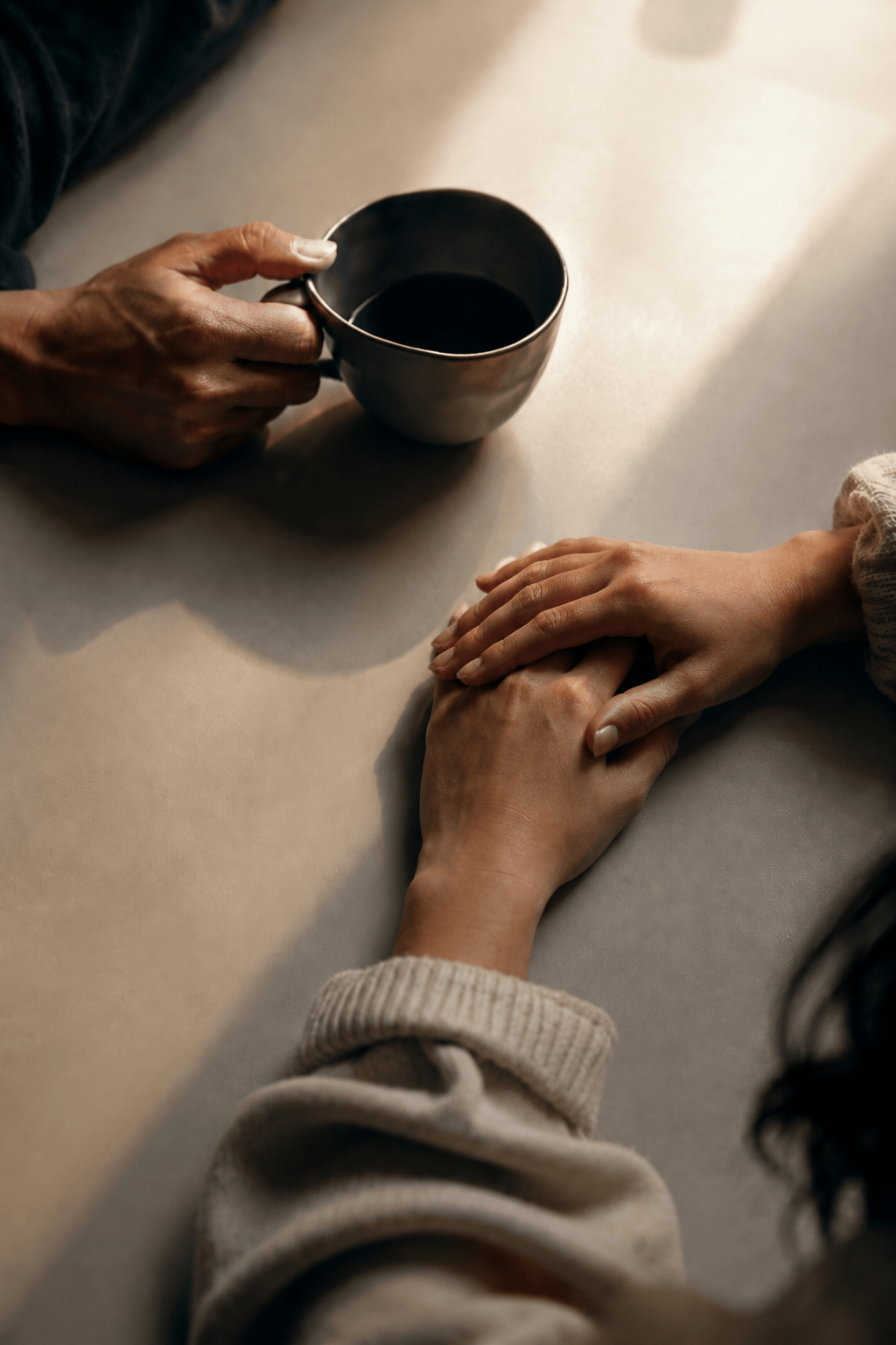 Top-down view of therapist and client holding coffee cups during counselling in Sydney.