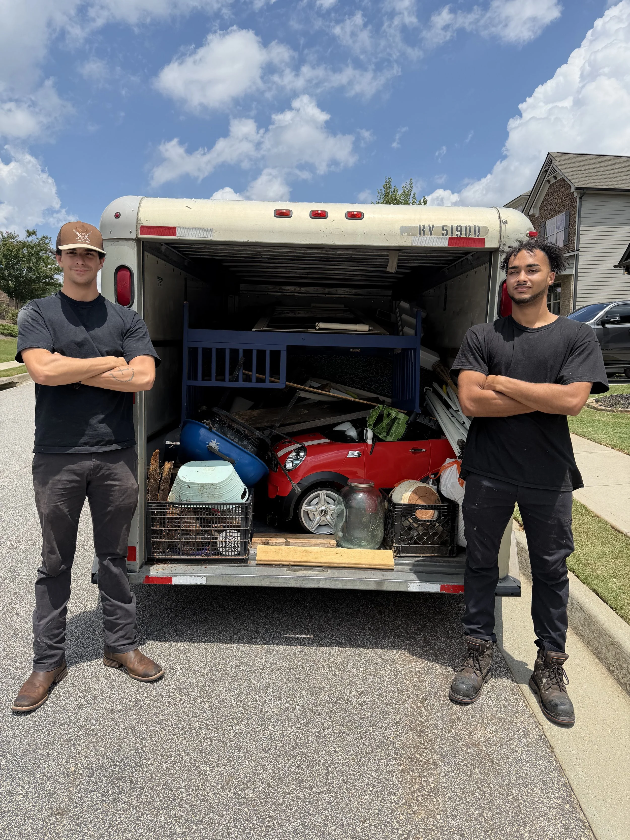 No Pain Junk Removal team in front of a full trailer after a junk removal job in Hall County, GA