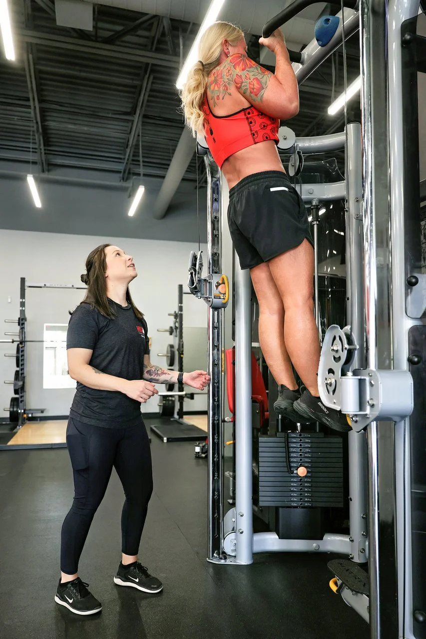 Hixon Fitness member Felicia completing a bodyweight pull up during a personal training session with Coach Lacey Warner