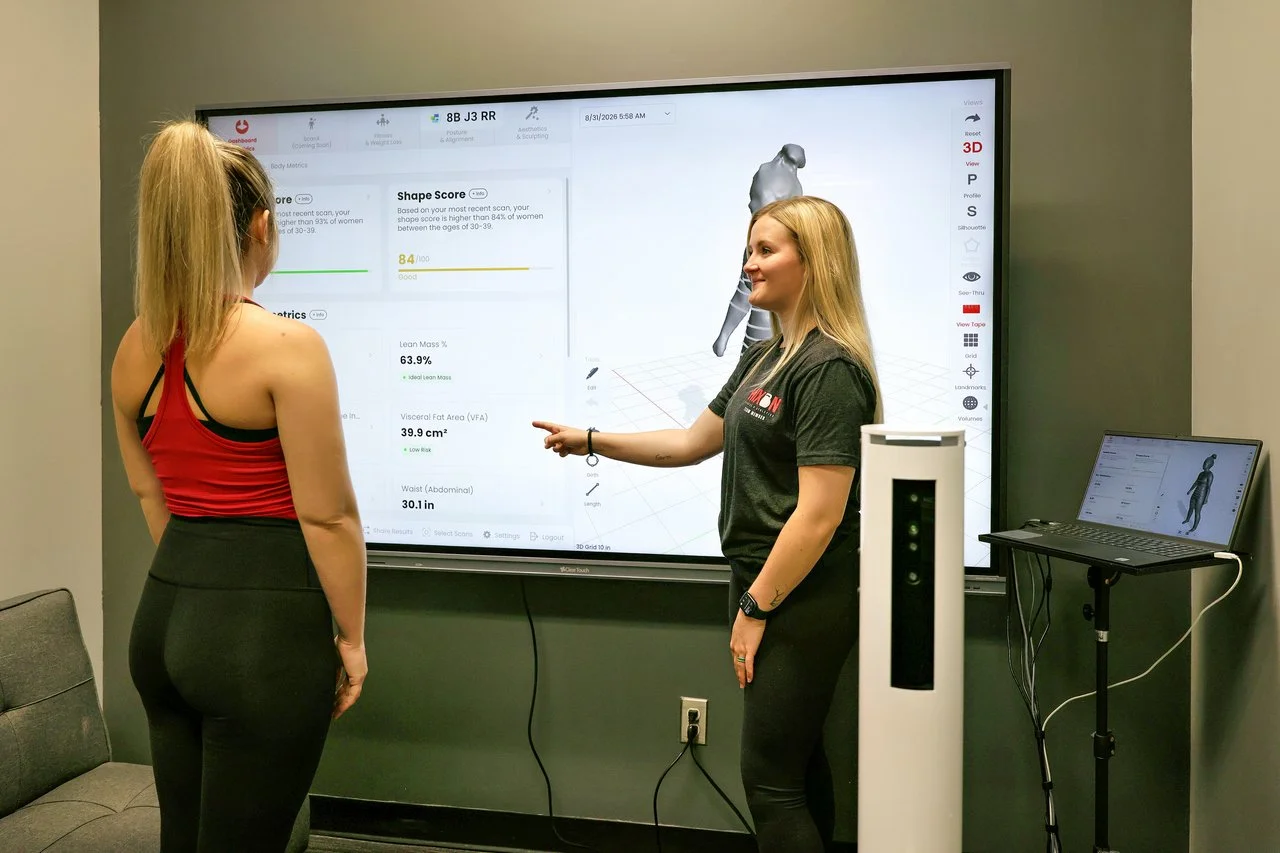 Fitness professional reviewing Styku body composition scan results with a client