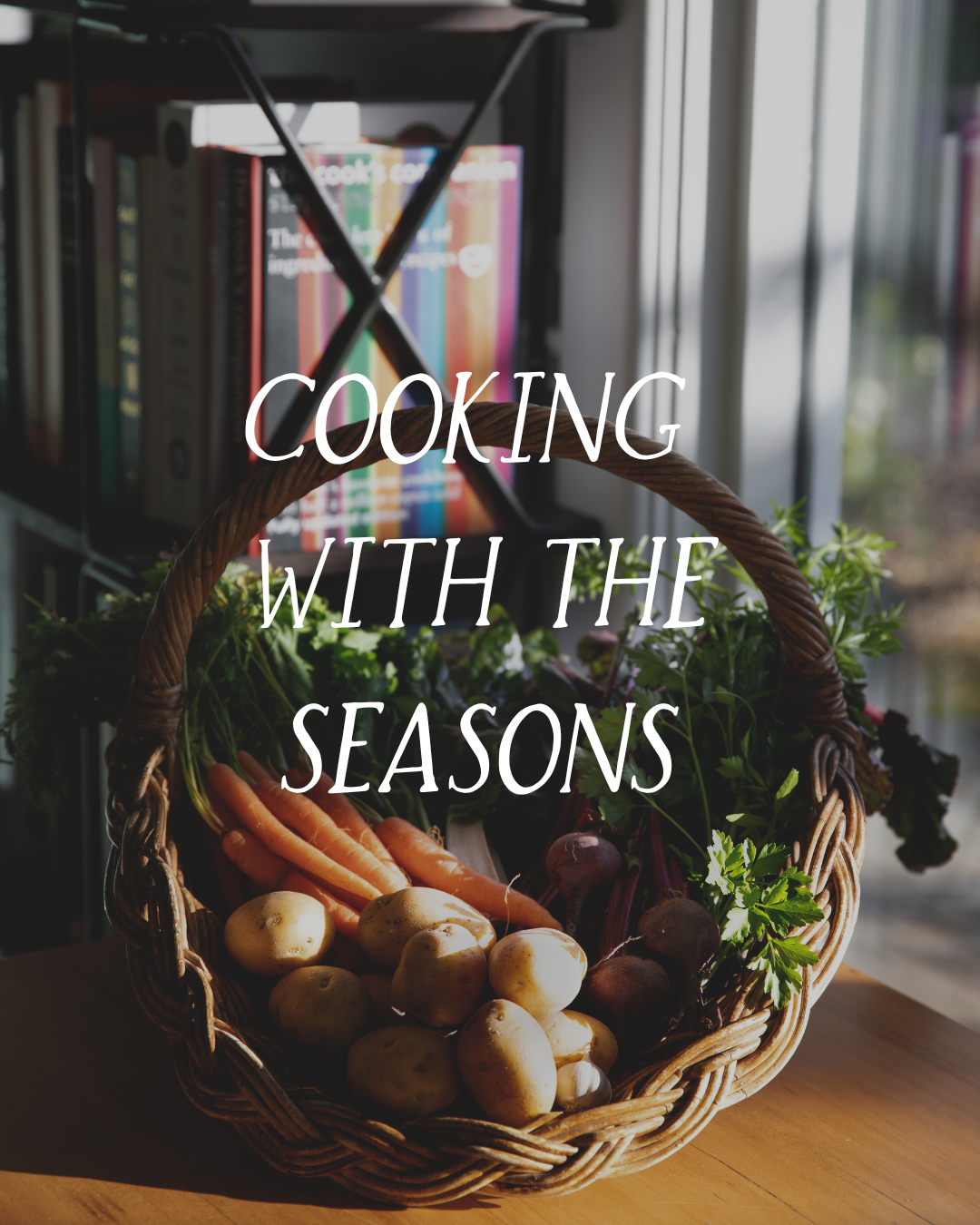 Basket of fresh vegetables including potatoes, carrots, and beets placed on a wooden surface with a background of bookshelves and a window.
