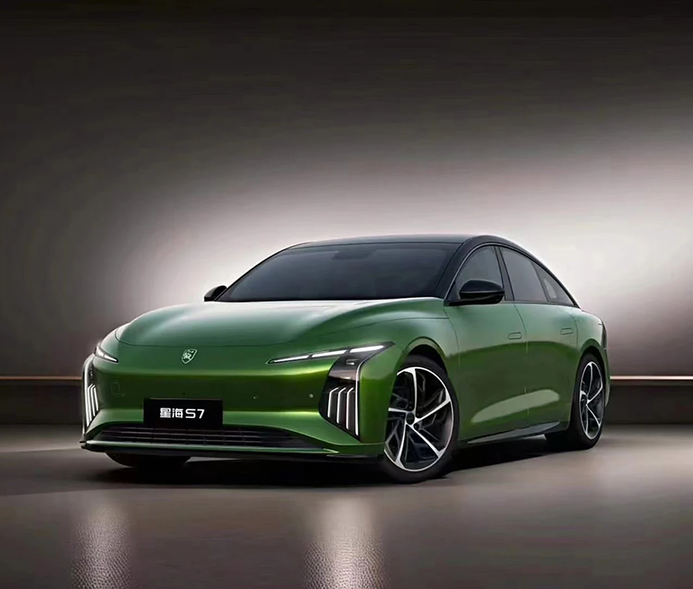 Ein grüner, moderner Elektroauto mit dunklem Dach, seitlicher Ansicht, in einer beleuchteten Raum.