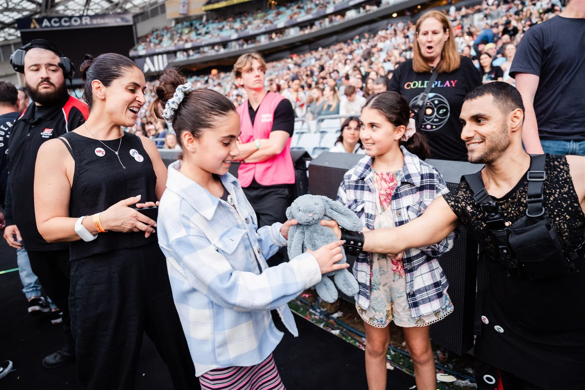 Emmanuel Kelly greeting fans after the concert, surrounded by supporters at the stadium.