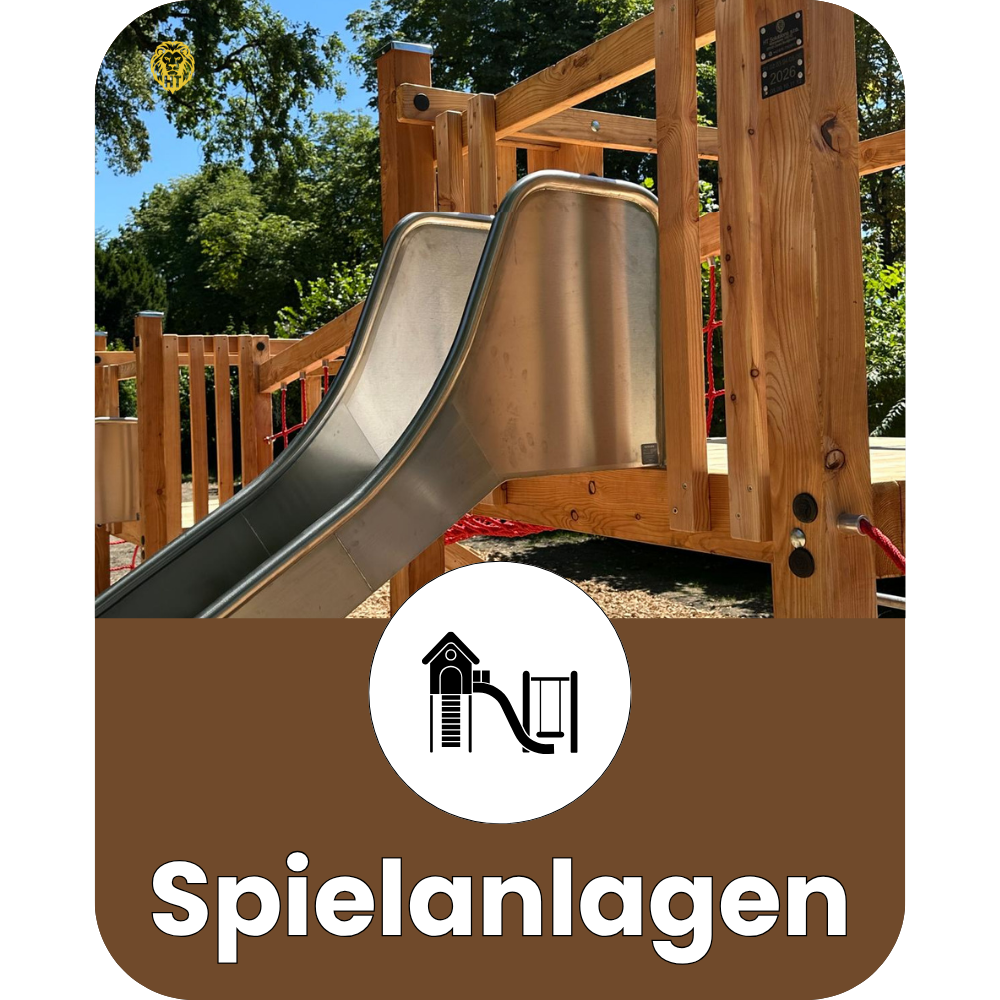 Holzspielplatz mit Rutsche im Freien, umgeben von Bäumen, mit einem Logo und dem Wort "spielanlagen" im unteren Bereich.