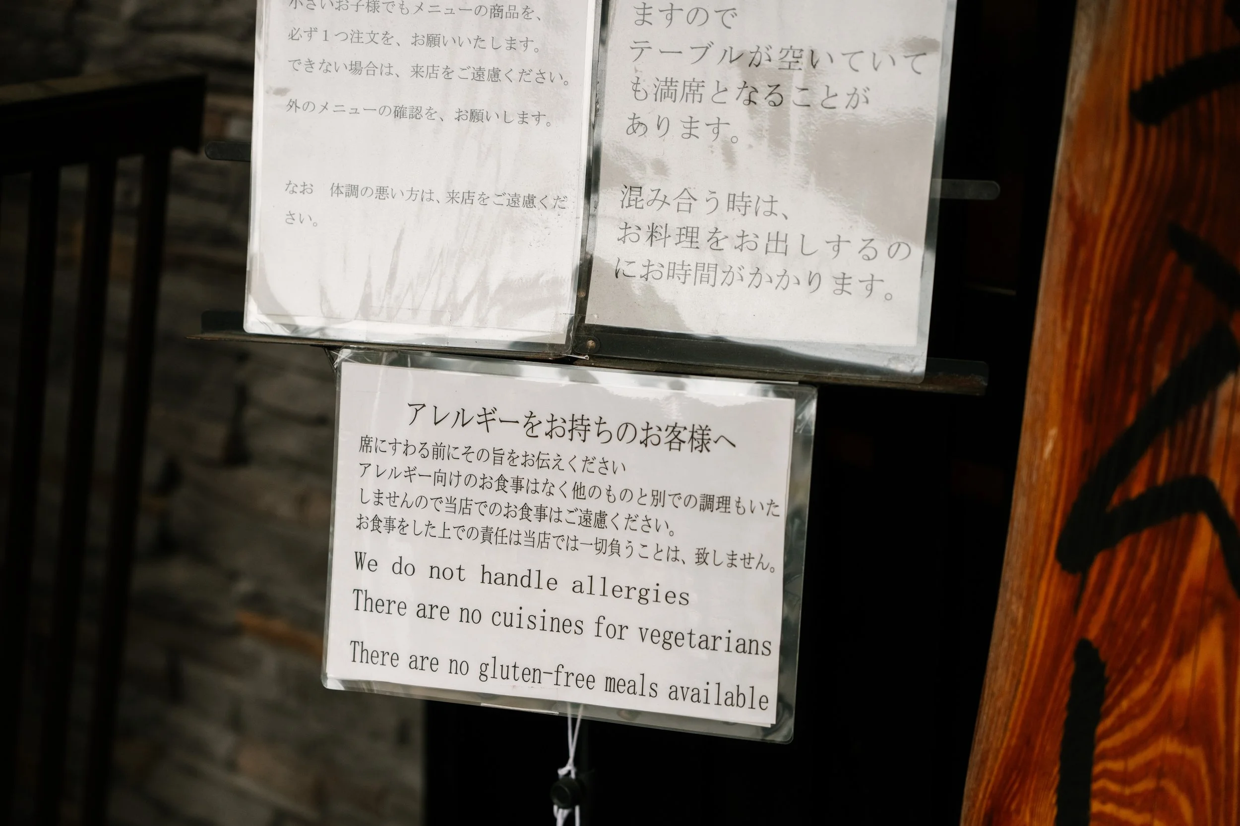 Sign with rules for customers, including no handling allergies, no vegetarian or gluten-free meals, and no cuisines for vegetarians.