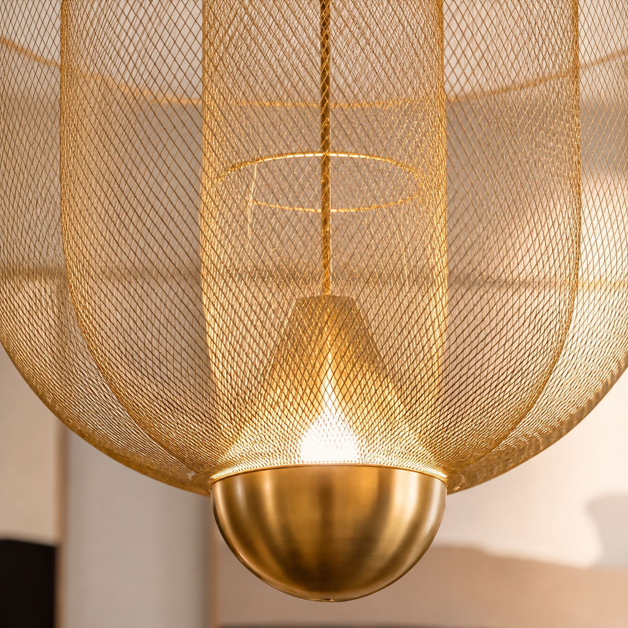 Statement pendant light with gold mesh detailing featured in a contemporary living room interior.
