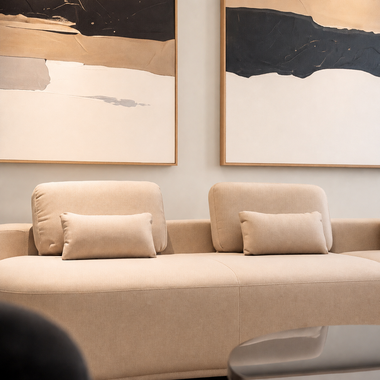 Neutral living room interior featuring a beige sofa and large abstract artwork in a warm contemporary design.
