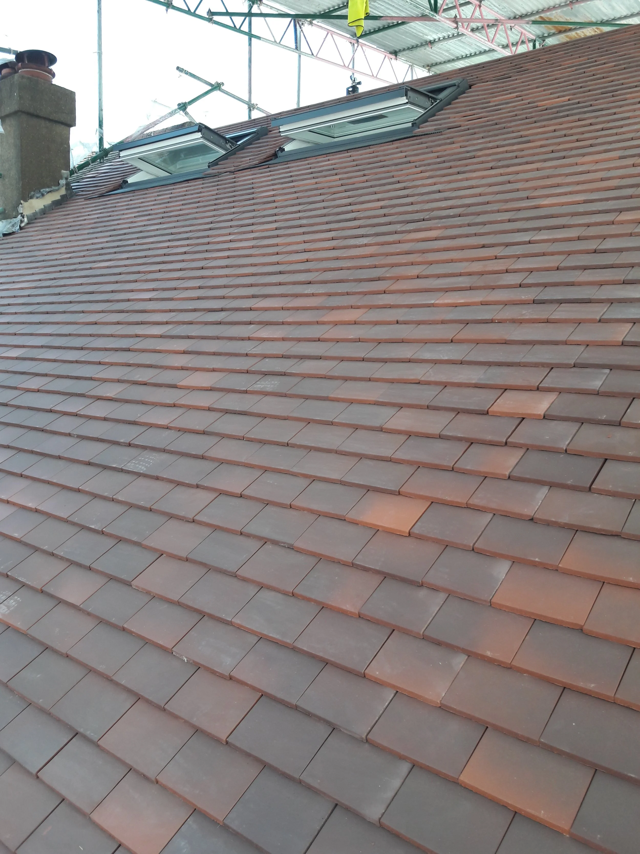 New red clay tiled roof with two installed skylights.