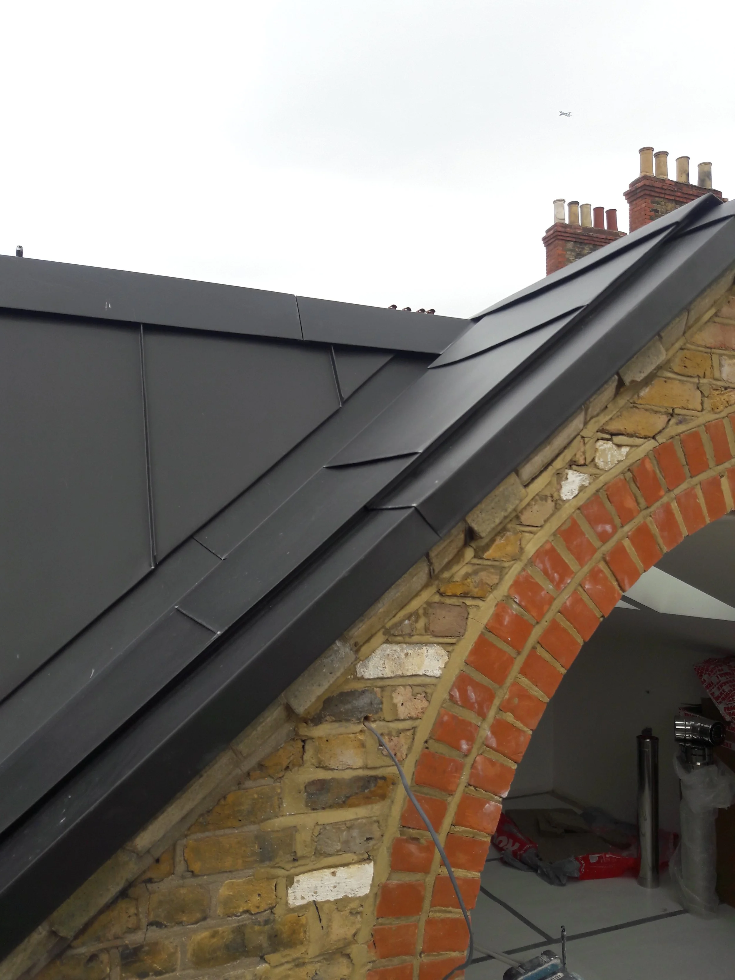 Renovation project on a sloped roof with metal panels.