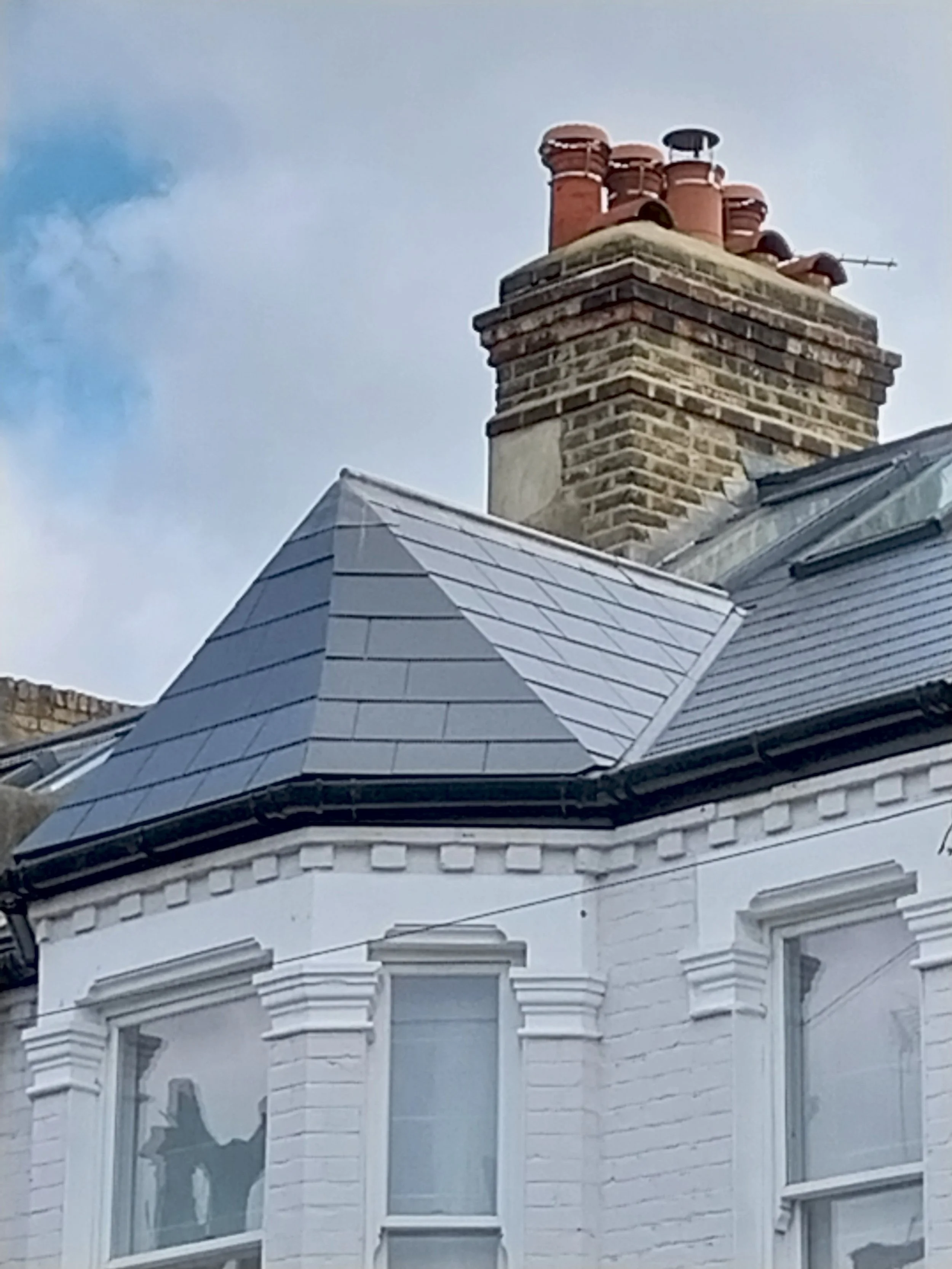 House with multi-sloped with dark shingles.