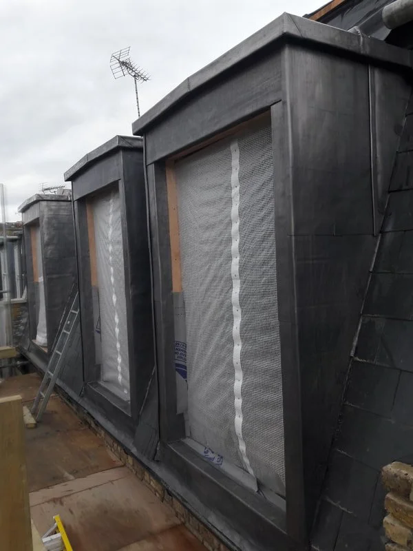 Zinc cladding (traditional folded sheet detailing) to a penthouse terrace elevation.