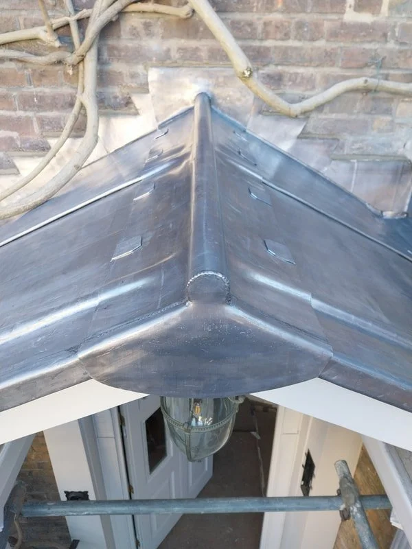 Close-up of a metal roof corner with a metal flashing cap.